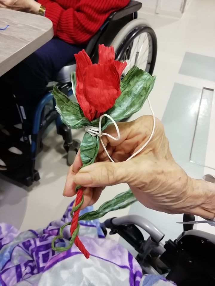 Paperiruusu vanhuksen kädessä