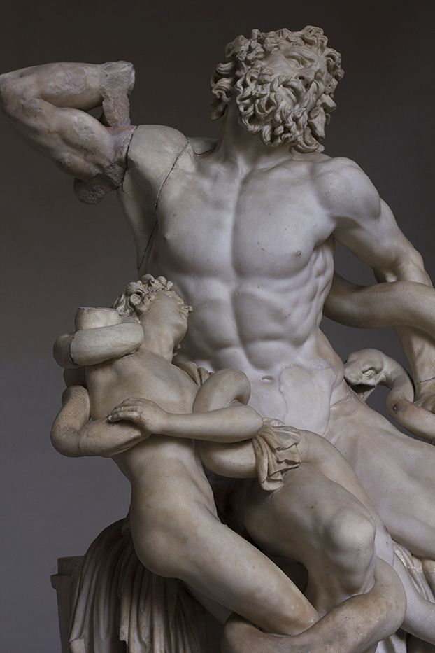 Marmoripatsas, jossa keskiössä parrakas, lihaksikas mieshenkilö ja etualalla toinen, pienempi ja nuorempi mieshenkilö. Molemmmat kamppailevat käärmeiden kanssa.