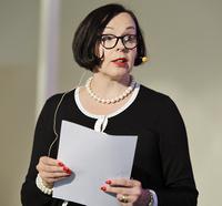 Puolilähikuva Liisamaija Hautsalosta paperi kädessä.