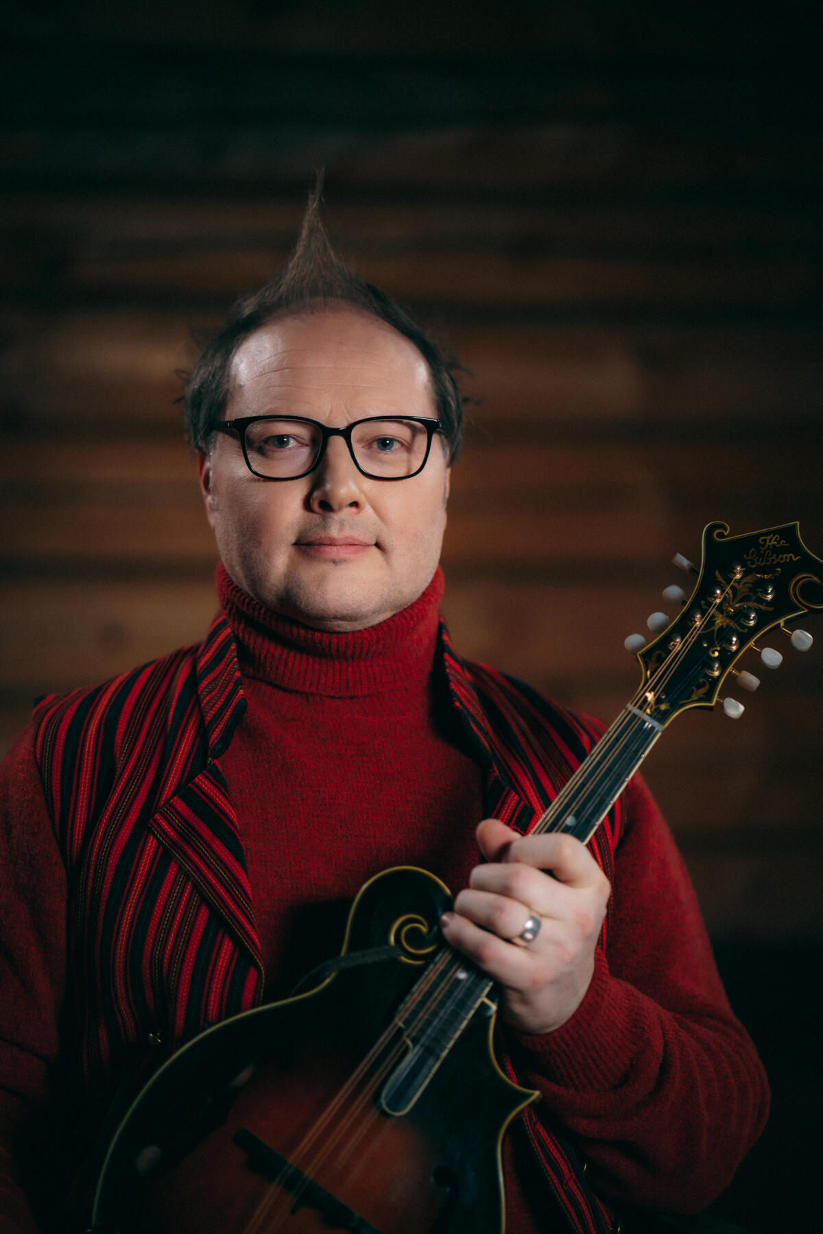 Petri katsoo kameraan mandoliini kädessään.