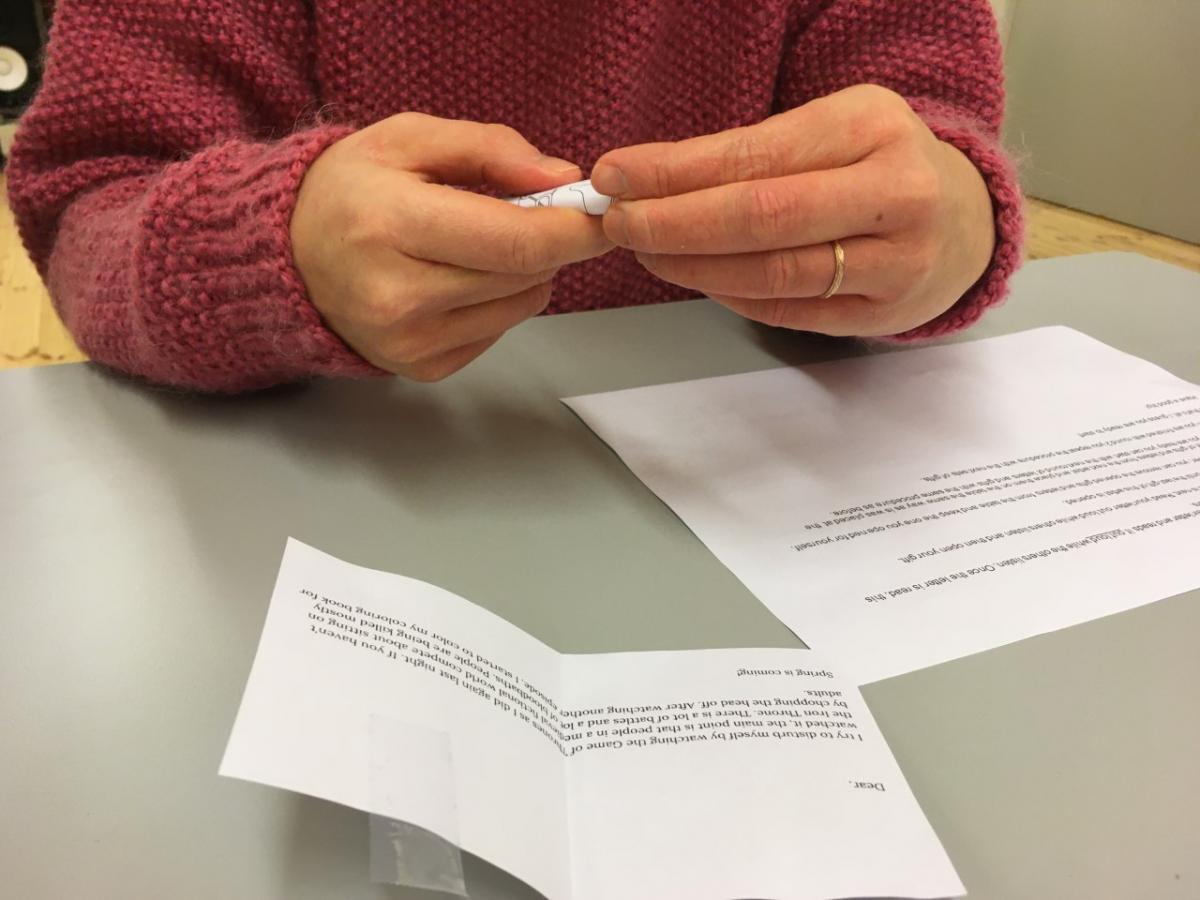 Persons hands in a closeup, opening a letter.
