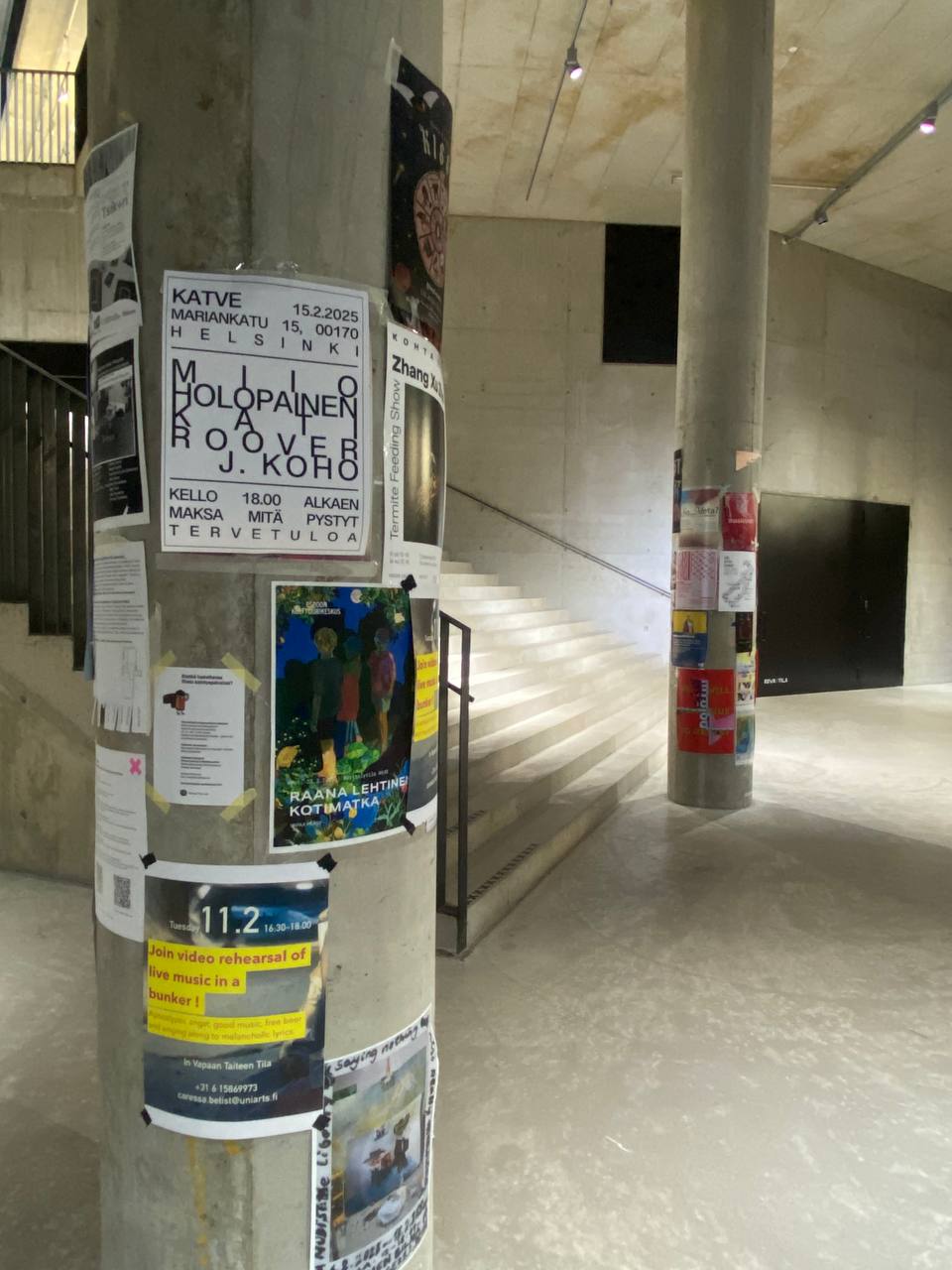 Pillars with posters inside the Mylly entrance.